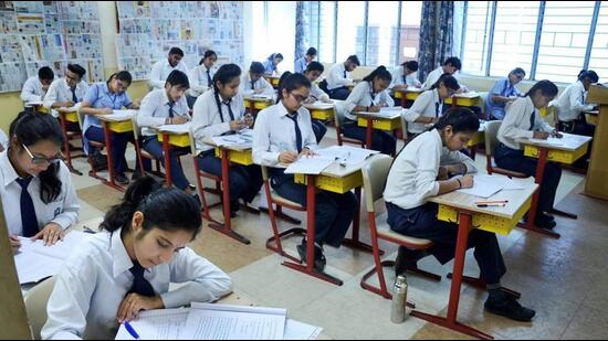 Exam hall during CBSE Class 10 board exams with students writing.